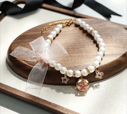 Collar de perlas c/dijes y campanita.