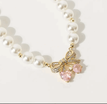 Collar de perlas c/dije de moño en piedra.