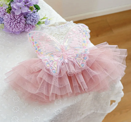 Vestido blanco trabajado c/tutu celeste decorado c/alitas. Talle M